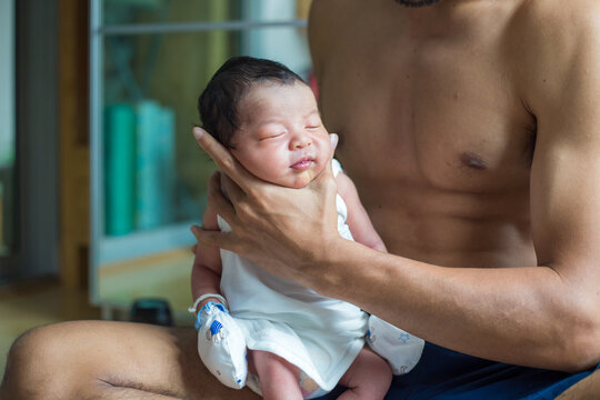 Beautiful young Asian father hold newborn baby boy with hand to help baby belch or Making burp after feeding