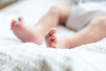 Obraz na płótnie Canvas Baby feet close up lying on bed happy Family concept
