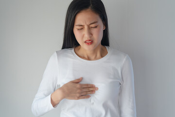 Asian woman having reflux acids and pain in the chest.