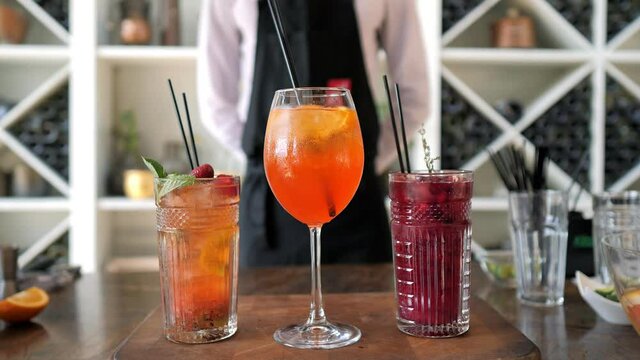 Bartender finished up cocktails with fresh orange juice and berries