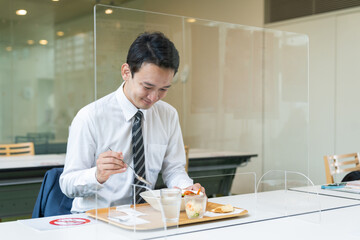 アクリルパーティションの前で食事する男性　飲食店の感染対策