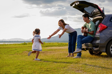 happy little girl with family sitting in the car.Car insurance concept