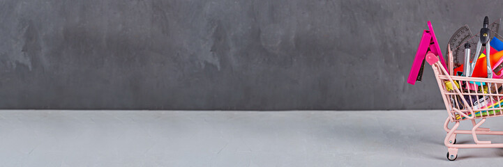 Back to School background with grocery cart. Collection of school supplies. Educational concept. Copy space, mockup, template.