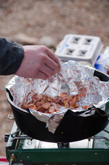 Breakfast being prepared in a foil-lined dutch oven.