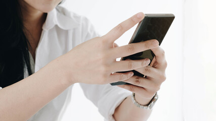 Closeup image of a beautiful Asian woman holding , using and looking at smart phone with feeling happy