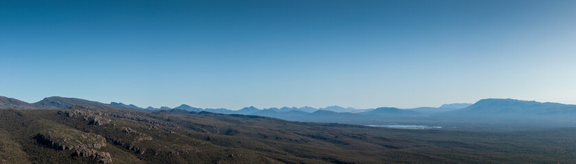 Fototapeta premium wide panorama showing the densely forested Grampians national park mountain range stretching off into the distance on a clear summer day, regional Victoria, Australia