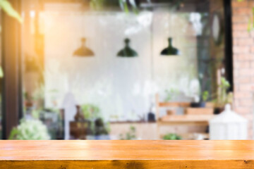 Empty brown wooden table and Coffee shop interior with some people meeting blur background with bokeh image,can be used for montage or display your products
