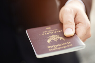 business man hand holding submit offer a passport thailand. asian travel world concept.