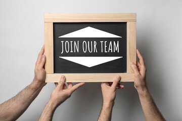 Men holding small chalkboard with phrase Join our team