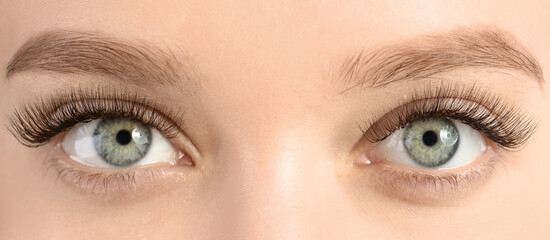 Obraz premium Young woman with beautiful long eyelashes, closeup view. Banner design