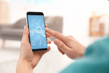 Keywords research concept. Man using smartphone indoors, closeup
