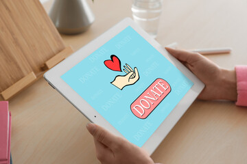 Donations concept. Woman with tablet at wooden table, closeup