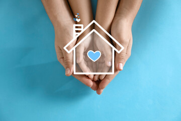 Illustration of house and happy family holding hands on blue background, top view