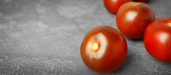 Fresh ripe brown tomatoes on grey table, closeup. Banner design