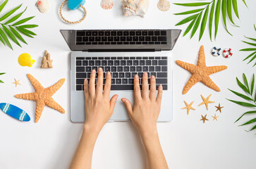 Working vacation them with laptop and beach travel items