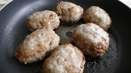 meat cutlets are fried in a frying pan