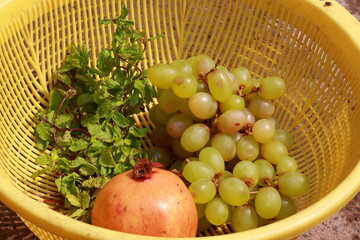 grape pomagranate and mint in yellow basket assorted fruit