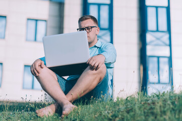 Businessman with a blue jacket on a gray background with a laptop in his hands.