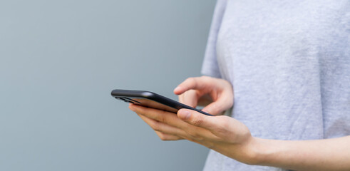 Closeup of young woman hand holding smartphone and chatting with friends at social network.