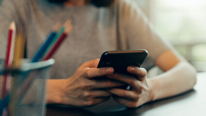 Closeup of young woman hand holding smartphone and chatting with friends at social network.