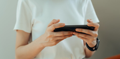 Closeup of young woman hand holding smartphone and chatting with friends at social network.