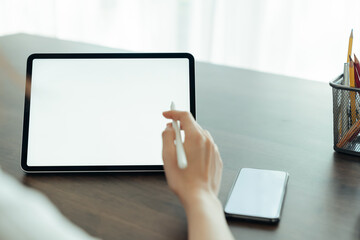 Closeup of woman hand holding digital tablet on the table and the screen is blank.