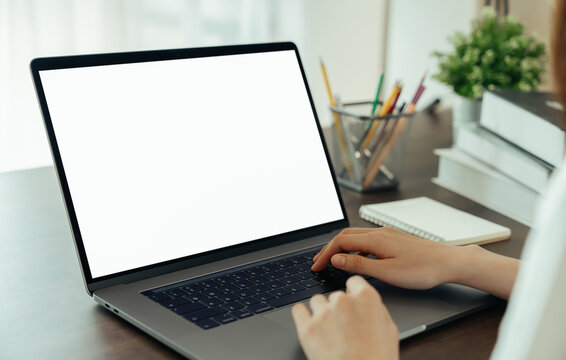 Woman had using laptop white screen and stationery on the table.