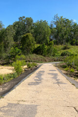 Fototapeta na wymiar Run-down concrete causeway on the Barron River near Kuranda in Tropical North Queensland, Australia