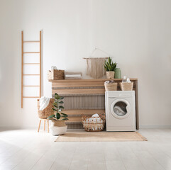 Modern washing machine and plants in laundry room interior