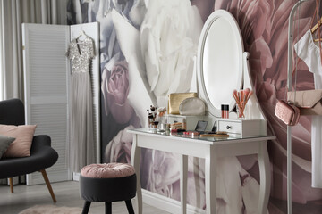 Stylish room interior with elegant dressing table and floral wallpaper