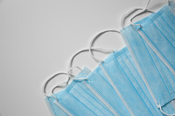 Disposable face masks on light background, flat lay. Protective measures during coronavirus...