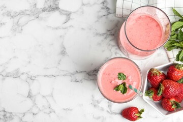 Tasty strawberry smoothies with mint in glasses on white marble table, flat lay. Space for text