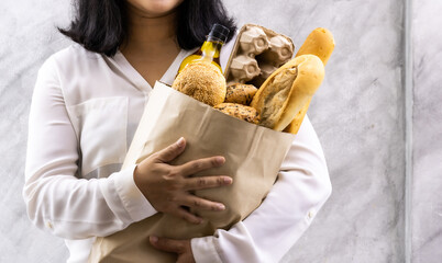 Close up Asian housewife woman hold grocery bread bag.