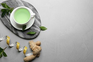 Flat lay composition with herbal diet tea and measuring tape on light table. Space for text