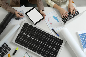 Architects working on house project with solar panels at white table, top view. Alternative energy...
