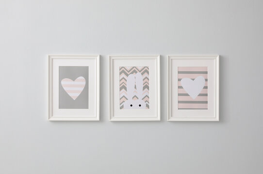 Different cute pictures on grey wall. Baby room interior