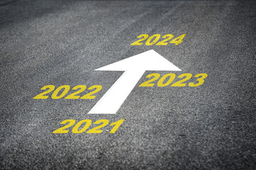 Year 2021 to 2024 and white arrow marking on road surface, business challenge concept and keep...