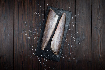 Directly above photo of two clean fresh whole fish on dark wooden background, ingredients,  prepared