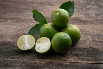 pile of limes on old wooden table.