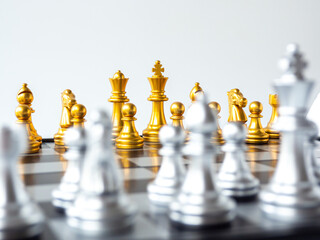 Gold king chess piece face and the golden team on the chessboard.