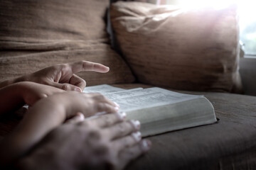 Fototapeta premium Child and father hands reading the Bible, Close up, Christian family concept.