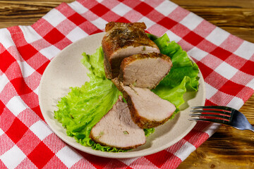 Tasty baked pork with spices on a wooden table