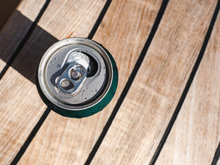 OCan of beer on the background of a beautiful, wooden surface. Directly above, close-up. Concept of...