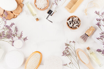 Fototapeta na wymiar Elegant light natural bath accessories and beauty products for hygiene and body care with lavender twigs on white background, copy space, border.