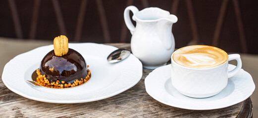 Cup of fresh cappuccino. Chocolate cake. Closeup. Cappuccino in a cup, hot latte, delicious coffee. Coffe time. Coffee or coffe cup at cafe in the morning