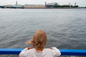 Little girl on the board of the ship. Aboard the ship. Travel by Saint Petersburg. Summer vacation concept. Family vacation concept. Baby from behind. Cruise concept