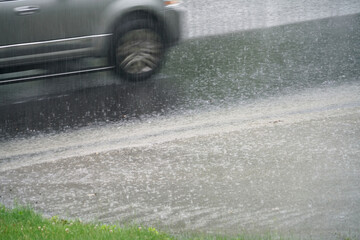 close up on moving car driving through rainy street