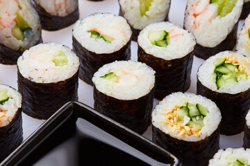 Various kinds of sushi roll set served on cutting board. Japanese food