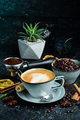 Obraz na płótnie Canvas Cappuccino coffee with milk in a cup. On a black stone background. Menu bar.