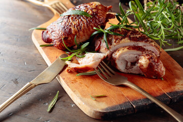 Smoked chicken  thighs with rosemary on a cutting board.